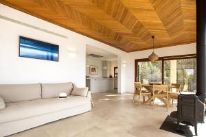 sala de estar con sofá blanco y techo de madera en Sa Casa des Mirador, en Fornalutx
