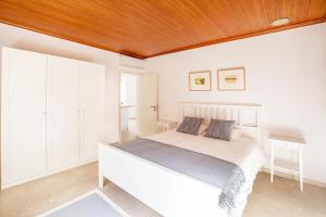 1 dormitorio blanco con 1 cama y techo de madera en Sa Casa des Mirador, en Fornalutx