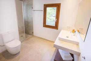 a bathroom with a toilet and a sink and a shower at Sa Casa des Mirador in Fornalutx +21 photos