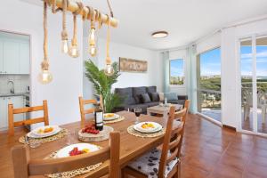 uma sala de jantar e sala de estar com mesa e cadeiras em Santa Susanna Sunrise Apartment em Santa Susanna