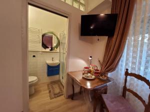a bathroom with a table and a toilet and a television at Annadia Sweet Home B&B in Lido di Ostia +104 photos