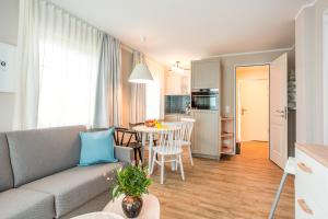 a living room with a couch and a table at BEECH Resort Fleesensee in Göhren-Lebbin