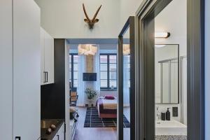 ROOMA Apartments في فيلنيوس: ممر مع حمام مع حوض استحمام وغرفة نوم