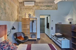 a bedroom with a bed and a chair in a room at ROOMA Apartments in Vilnius