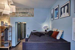 a bedroom with a large bed and blue walls at ROOMA Apartments in Vilnius