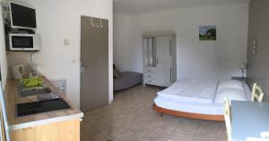 ein kleines Schlafzimmer mit einem Bett und einem Waschbecken in der Unterkunft Le Mas des 3 Anes in Blars
