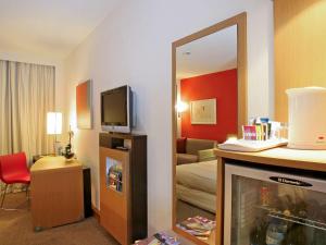 a hotel room with a mirror and a living room at Novotel Porto Gaia in Vila Nova de Gaia +37 photos