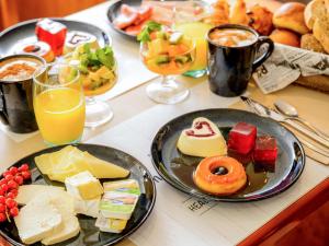 a table topped with plates of food and drinks at Novotel Porto Gaia in Vila Nova de Gaia