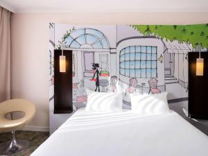 a bedroom with a bed and a painting of a restaurant at ibis Styles Evry Courcouronnes Hotel and Events in Evry-Courcouronnes