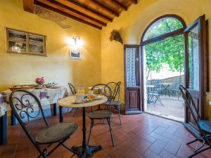 uma sala de jantar com mesa e cadeiras e uma porta aberta em Paradiso in Chianti em Gaiole in Chianti