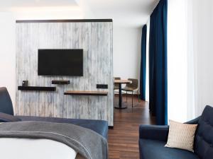 a living room with a tv on a wall at the niu Saddle - Apartments in Fürth