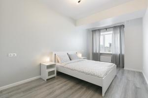 a white bedroom with a bed and a window at GERBERA APARTMENT 3к ЖД Вокзал Аквапарк Центр in Novosibirsk