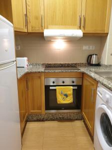 a kitchen with a stove with a yellow towel at Apartamentos Marina Playa de Torrevieja in Torrevieja