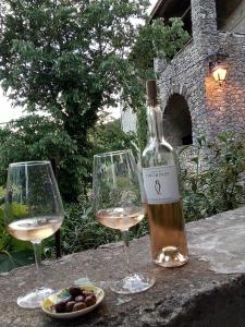 Gite des Gorges de l'Ardèche في Chame: زجاجة من النبيذ وكأسين على الطاولة
