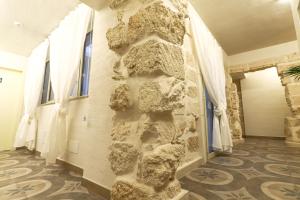 a stone wall in a hallway with windows at 7Palazzi in Lampedusa