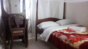 una camera con un letto con una sedia e un copriletto di Nasera Suites Hotel a Moyo