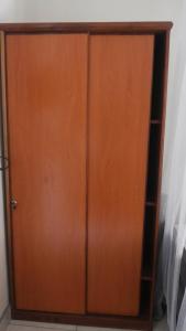 un armario de madera con puerta en una habitación en Nasera Suites Hotel, en Moyo