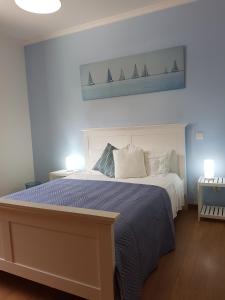 Un dormitorio con una cama con una pintura de barcos. en FX Pena en Funchal