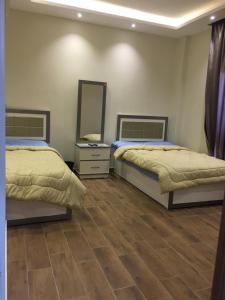 una camera con due letti e uno specchio di Ramco For Furnished Apartments And Accommodation Compound Leila a Il Cairo