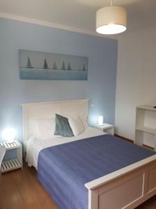 a bedroom with a bed with a blue comforter and sailboats at FX Pena in Funchal