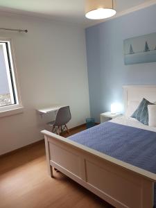 um quarto com uma cama, uma secretária e uma janela em FX Pena em Funchal