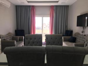 Ramco For Furnished Apartments And Accommodation Compound Leila في القاهرة: غرفة معيشة مع كنب وتلفزيون بشاشة مسطحة