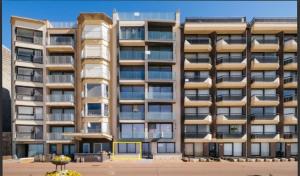 a large apartment building with a lot of windows at Zilverzand aan zee - frontaal zeezicht in Koksijde