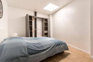 - une chambre avec un lit et une étagère dans l'établissement Le ZEN... appartement avec fauteuil massant!, à Tourcoing