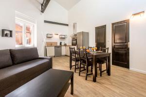 een woonkamer met een bank en een tafel met stoelen bij Le ZEN... appartement avec fauteuil massant! in Tourcoing