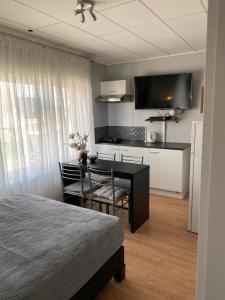 Cet appartement comprend une chambre avec un lit et une table ainsi qu'une cuisine. dans l'établissement Homestay Mimi's Rental, à Bruges
