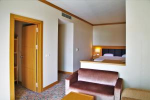古雷阿德林娜特马尔健康温泉酒店的配有一张床和一把椅子的酒店客房