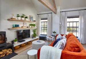 a living room with a couch and a tv at The Loft House - Beautiful House in Best Location in Bath