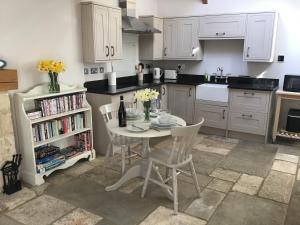 a kitchen with a table and chairs in a kitchen at Courtyard Cottage in Stroud