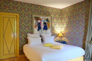 a bedroom with a large white bed with floral wallpaper at Domaine Saint Clair - Le Donjon in Étretat