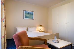 a hotel room with a bed and a chair at acora Bonn Living the City - Apartments in Bonn