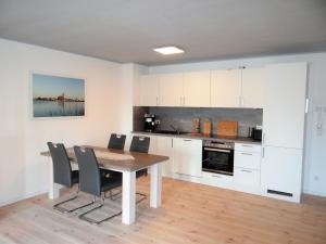 a kitchen with a table and chairs in a room at Speicher Residenz Barth E4 App 9 in Barth