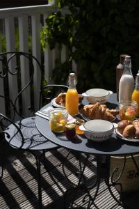 a table with a tray of food and orange juice at Domaine Saint Clair - Le Donjon in Étretat