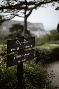 a sign with arrows on it in a park at Domaine Saint Clair - Le Donjon in Étretat