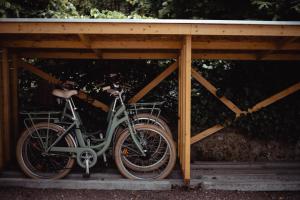 a bike is parked under a wooden structure at Domaine Saint Clair - Le Donjon in Étretat