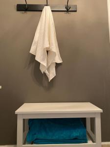 a white bench with a towel hanging on a wall at Stara Studnia in Brzeźnica Stara