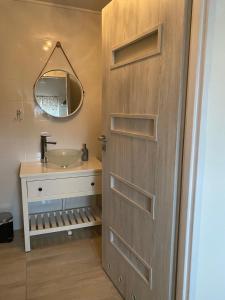 a bathroom with a wooden door and a sink at Stara Studnia in Brzeźnica Stara