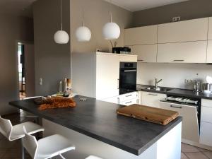 una cucina con piano di lavoro nero e armadietti bianchi di Apartment in Landau Stadtoase a Landau in der Pfalz