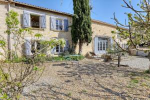 - une vue sur l'extérieur de la maison avec des arbres dans la cour dans l'établissement Maison de 4 chambres avec piscine privee jardin clos et wifi a Montignac Charente, à Montignac-Charente