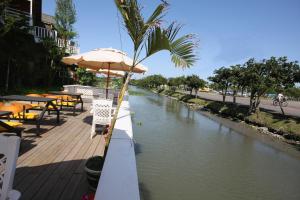 a river with tables and chairs and an umbrella at Dongshan River Resort Farm in Wujie
