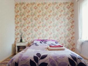 Palade的住宿－Palade Retrovisiit Meida，一间卧室配有一张带花卉壁纸的床