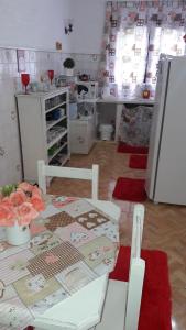 a kitchen with a table and chairs in a room at Chalé pinheiro velho in Monte Verde