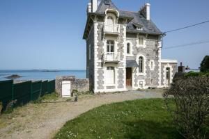 an old house on a hill next to the ocean at La Perle Marine - Bow-Window vue mer in Dinard +5 photos