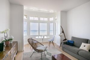 a living room with a couch and a table at La Perle Marine - Bow-Window vue mer in Dinard