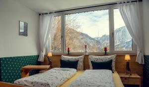 um quarto com 2 camas e uma grande janela em Ferienwohnung Leuner em Altaussee