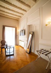 a living room with a table and a mirror at Splendor Suite Rome - Suites & Apartments in Rome